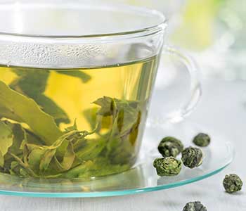 Cup of Jasmine Pearl Tea Opening in Water