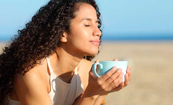 Best tea for anxiety - girl relieving anxiety with tea on beach