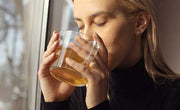 girl drinking the best tea for stress near window