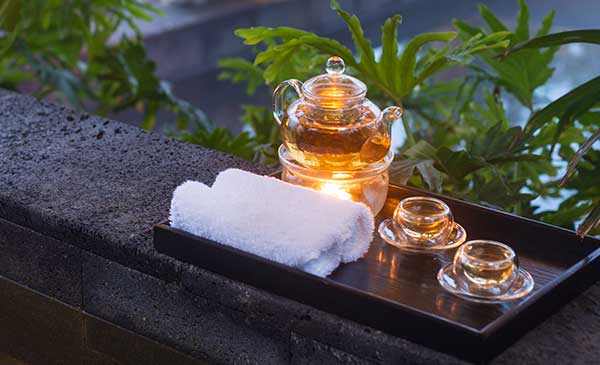 Relax with caffeine free tea - glass teapot with spa towels and soothing green plants