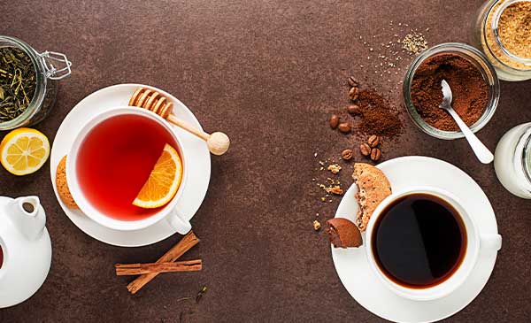 a cup of tea and cup of coffee on table with cookies