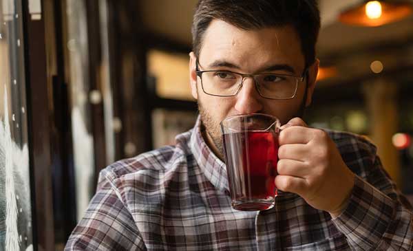 is black tea good for you? Man drinking a cup and thinking.