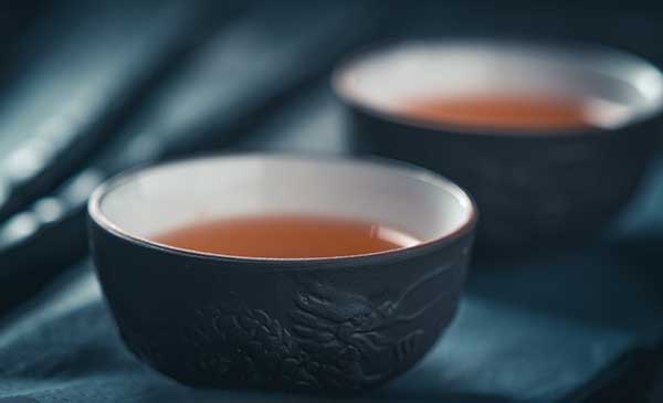 Two small black cups of flavorful oolong tea