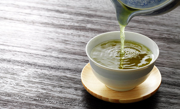 Pouring a cup of delicious tasting green tea 