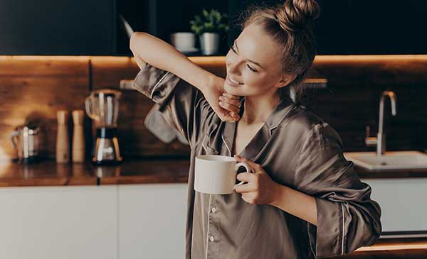 woman in kitchen waking up with tea
