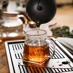 pu erh tea poured into small glass pitcher