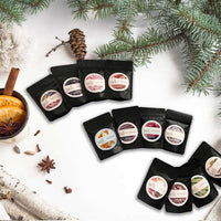 12 pouches of christmas tea arranged in a circular pattern on a white surface with festive elements.