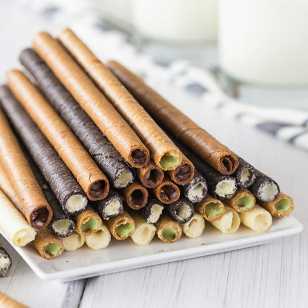 Assorted wafer cookies on a white plate with a blurred background