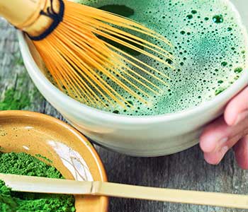 using matcha whisk to whisk matcha in bowl